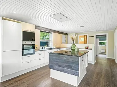a kitchen with white cabinets and a vase on a counter at Holiday Home Skip - 300m to the fjord by Interhome in Højslev