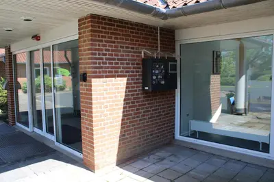 a brick wall with glass doors on a house at Hotel Traneparken in Nykøbing Mors
