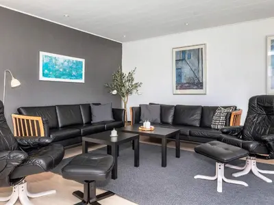 a living room with black leather couches and tables at 4 star holiday home in Blokhus-By Traum in Blokhus