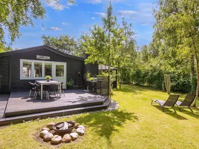 a tiny house with a patio and a table and chairs at 5 person holiday home in Thyholm-By Traum in Thyholm