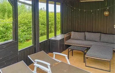 a porch with a bench and a table and chairs at 3 Bedroom Cozy Home In Vinderup in Vinderup
