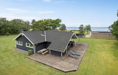 a house on a deck with a table and chairs at 3 Bedroom Cozy Home In Højslev in Højslev