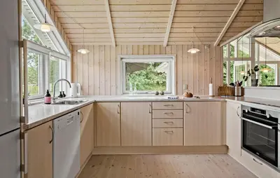 a kitchen with wooden cabinets and a window at 3 Bedroom Cozy Home In Højslev in Højslev