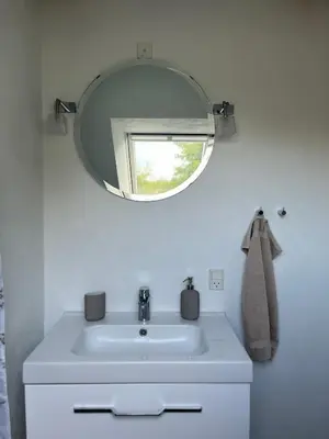 a bathroom with a white sink and a mirror at Thisted Centrum in Thisted