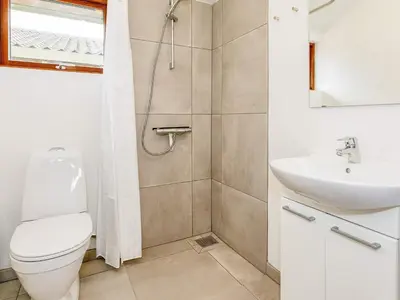 a bathroom with a shower and a toilet and a sink at 12 person holiday park home in Hanstholm in Hanstholm