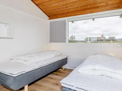two beds in a room with a window at 12 person holiday park home in Hanstholm in Hanstholm