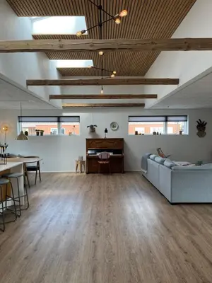 a living room with a couch and a table at Hus tæt ved havn og strand in Thyborøn