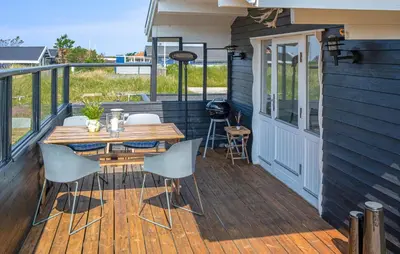 a wooden deck with a table and chairs on a house at 2 Bedroom Lovely Home In Thisted in Thisted