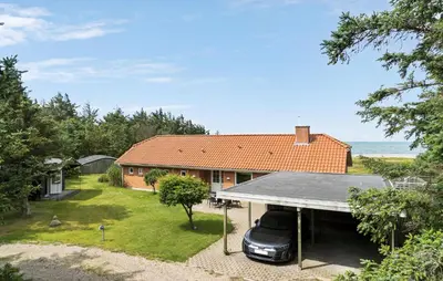 a car parked in the driveway of a house at 4 Bedroom Beach Front Home In Thyholm in Thyholm