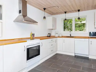 a kitchen with white cabinets and a stove top oven at 4 star holiday home in Gedsted-By Traum in Gedsted
