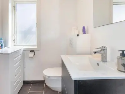 a white bathroom with a toilet and a sink at 4 star holiday home in Gedsted-By Traum in Gedsted