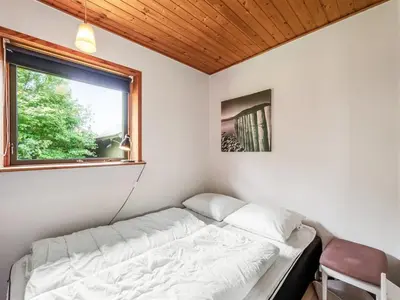 a bed in a room with a window at Holiday Home Arlin - 380m to the fjord by Interhome in Vemb