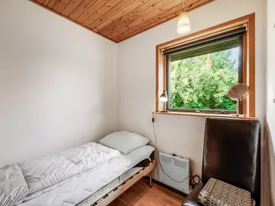 a small bedroom with a bed and a window at Holiday Home Arlin - 380m to the fjord by Interhome in Vemb