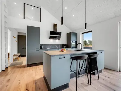 a kitchen with a counter and some stools at Holiday Home Dreng - 300m from the sea by Interhome in Harboør