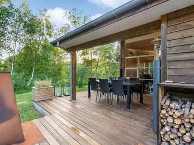 a wooden deck with a table and chairs on it at Holiday Home Zölestine - from the sea by Interhome in Fjerritslev