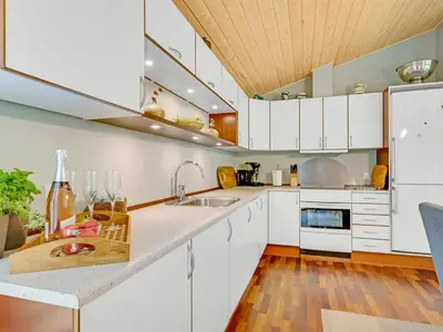 a kitchen with white cabinets and a wooden ceiling at Holiday Home Zölestine - from the sea by Interhome in Fjerritslev