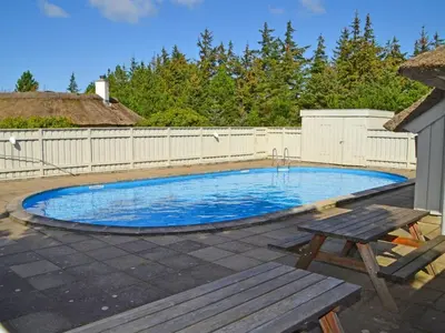 a swimming pool with a picnic table and a bench at Holiday Home Elenor - 1-1km from the sea by Interhome in Fjerritslev