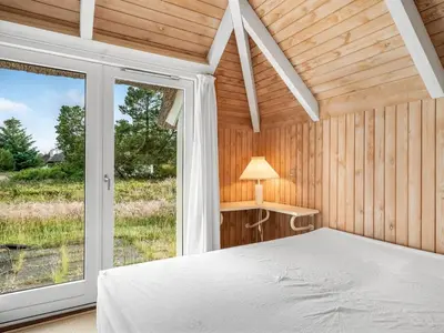a bedroom with a bed and a large window at Holiday Home Elenor - 1-1km from the sea by Interhome in Fjerritslev