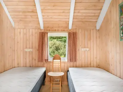 two beds in a room with a window at Holiday Home Elenor - 1-1km from the sea by Interhome in Fjerritslev