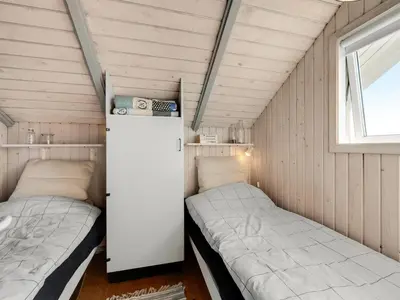 a small room with two beds and a refrigerator at Holiday Home Angelie - 400m from the sea by Interhome in Harboør