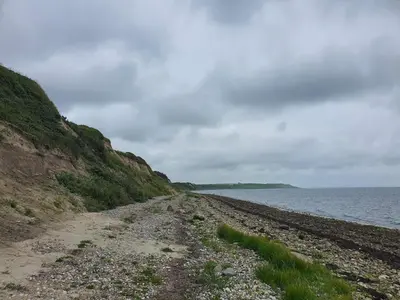 a dirt road next to the water on a beach at 7 person holiday home in Vestervig-By Traum in Vestervig
