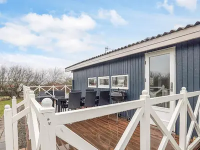 a blue house with a white fence and a deck at 7 person holiday home in Vestervig-By Traum in Vestervig