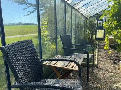 two chairs and a table on a screened porch at Light-filled Retreat in Boddum - By Traum Ferienwohnungen in Boddum