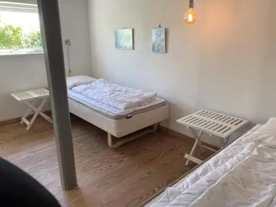 a small room with two beds and a window at Light-filled Retreat in Boddum - By Traum Ferienwohnungen in Boddum