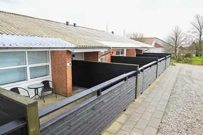 a house with a fence and a table on a patio at Rold Gl Kro in Arden