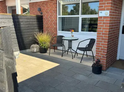 a patio with chairs and a table in a house at Rold Gl Kro in Arden