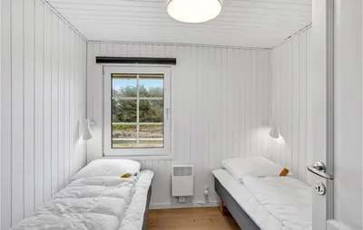 two beds in a white room with a window at 2 Bedroom Stunning Home In Harboøre in Harboør