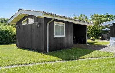 a black shed with a window and a table in a yard at 3 Bedroom Beautiful Home In Vinderup in Vinderup