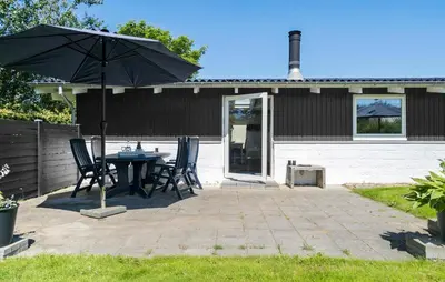 a patio with a table and chairs and an umbrella at 3 Bedroom Beautiful Home In Vinderup in Vinderup