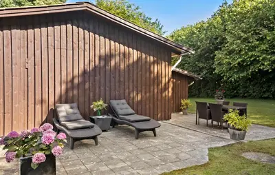 a patio with chairs and a table and a fence at 3 Bedroom Nice Home In Farsø in Farsø