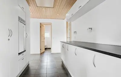 a kitchen with white cabinets and a black counter top at Amazing Home In Vesløs With Wifi in Øsløs