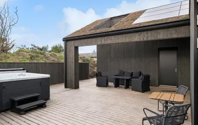 a patio with a tub and furniture on a deck at 4 Bedroom Pet Friendly Home In Blokhus in Blokhus