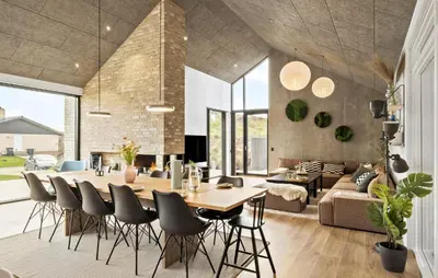 a dining room and living room with a table and chairs at 4 Bedroom Pet Friendly Home In Blokhus in Blokhus