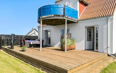 a house with a wooden deck with a balcony at 4 Bedroom Nice Home In Harboøre in Harboør