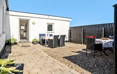 a patio with a table and chairs and a fence at 4 Bedroom Nice Home In Harboøre in Harboør