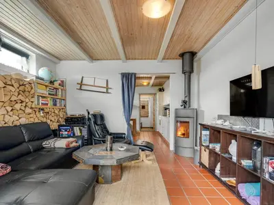 a living room with a couch and a table and a fireplace at Apartment Hansa - 300m from the sea by Interhome in Torsted