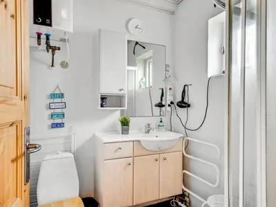 a bathroom with a sink and a toilet and a mirror at Apartment Hansa - 300m from the sea by Interhome in Torsted