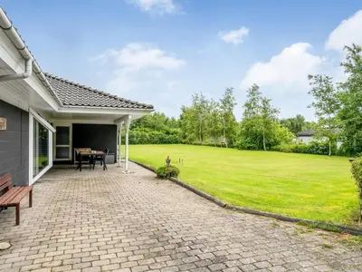 a patio with a table and a grass field at Holiday Home Lyra - 500m to the fjord by Interhome in Øsløs