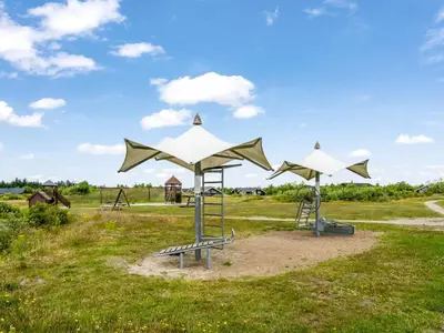 a playground with white umbrellas in a field at Holiday Home Lissi - 3-5km from the sea by Interhome in Brovst