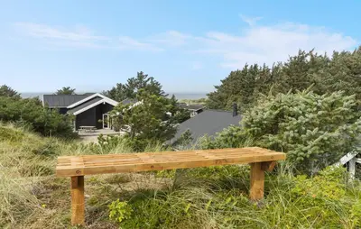 a wooden bench sitting on top of a hill at Awesome Home In Løkken With Kitchen in Løkken