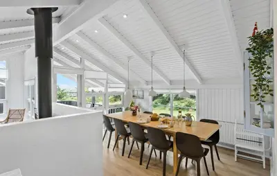 a dining room with a table and chairs at Awesome Home In Løkken With Kitchen in Løkken