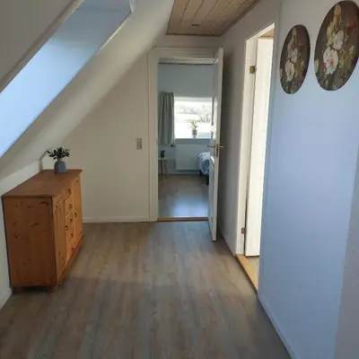 an attic room with a staircase and a wooden floor at Vakantiewoning Denemarken in Års