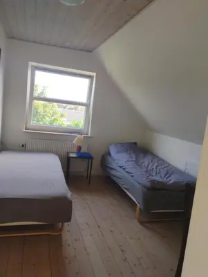 a bedroom with two beds and a window at Rødkælkevej's B&B in Hurup