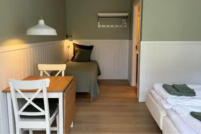 a bedroom with a bed and a table and chairs at Motel Gavlhuset in Nørager