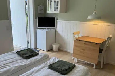a bedroom with a bed and a desk and a television at Motel Gavlhuset in Nørager