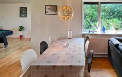 a dining room with a table with chairs and a lamp at 2 Bedroom Stunning Home In Erslev in Erslev